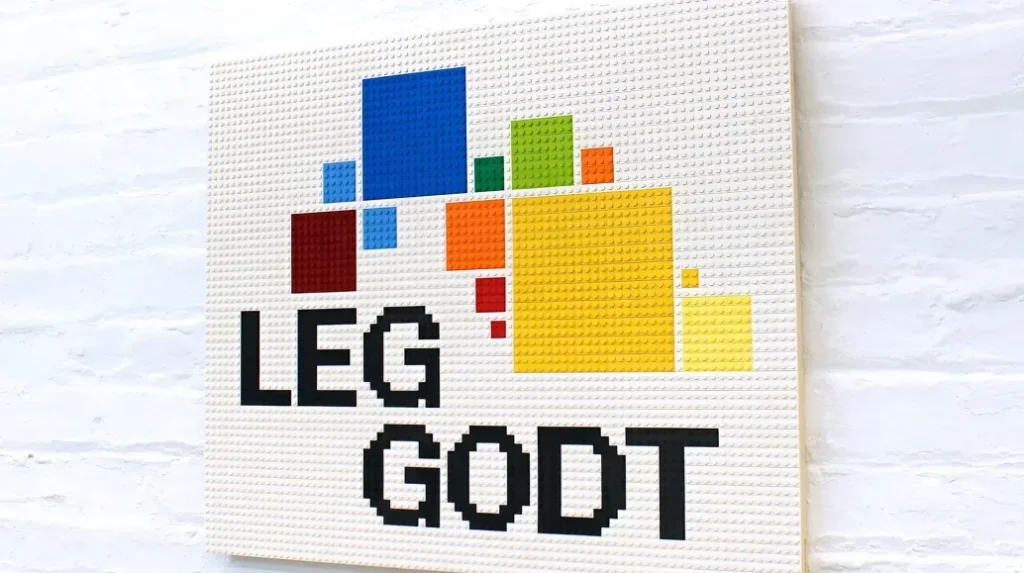 Назва походить від датського виразу «Leg godt!», що означає «Грай добре!».